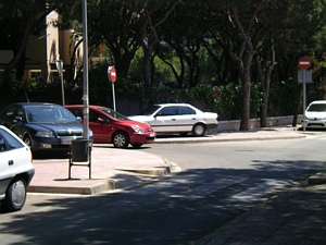 El coche blanco totalmente sobre la acera