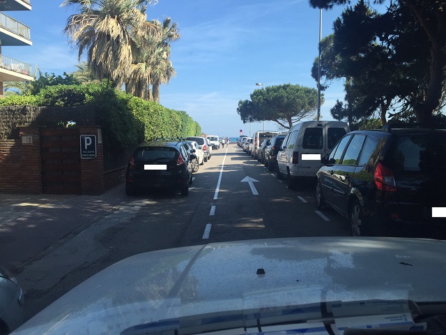 Cotxes aparcats imp�nement sobre la vorera al carrer de L'Escala de Gav� Mar, impedint el pas dels vianants i dificultant la circulaci� dels vehicles (6 de Juny de 2016)