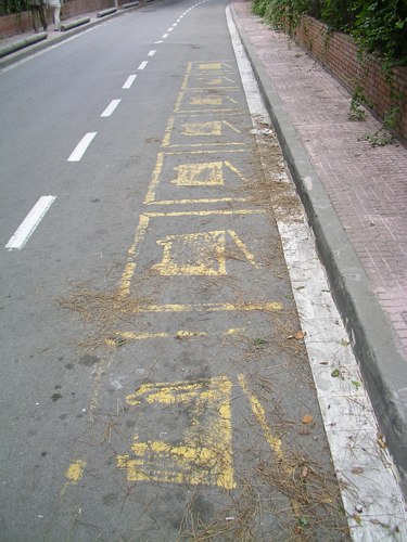 Pintades a l'asfalt que demostren el gran nombre de contenidors d'escombraries que hi havia al carrer Calafell per donar servei a Pine Beach