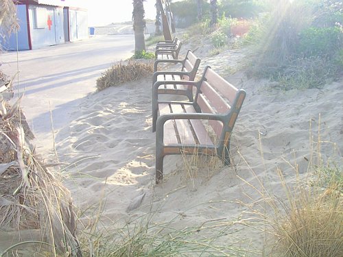Bancs del passeig marítim de Gavà Mar plens de sorra de la platja