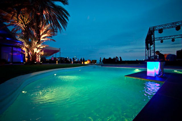 Imatge nocturna de la piscina del restaurant i beach club Tropical de Gav Mar 